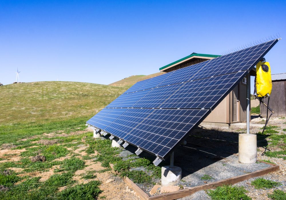Solar panels on the hills of east San Francisco bay area; wind turbines in the background; California
